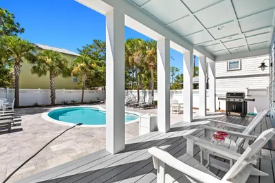 a patio with a pool and chairs and a grill at Sea Power in Santa Rosa Beach