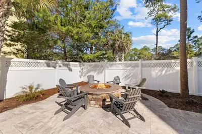a patio with a table and chairs and a fire pit at Sea Power in Santa Rosa Beach