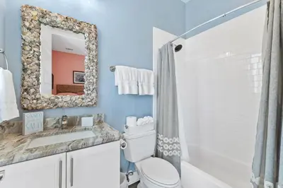 a bathroom with a toilet and a sink and a mirror at Sea Power in Santa Rosa Beach