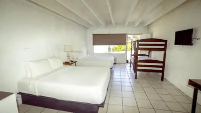 a bedroom with two beds and a chair in it at Banana Peel Lodge in Panama City Beach