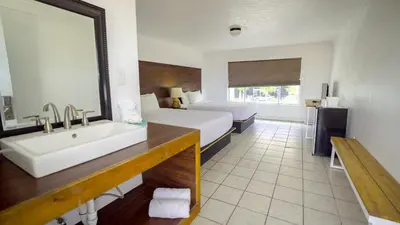 a bathroom with a bed and a sink in a room at Banana Peel Lodge in Panama City Beach