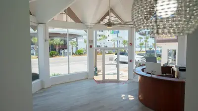 a lobby of a store with a counter and windows at Banana Peel Lodge in Panama City Beach