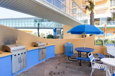 a patio with a table and a blue umbrella at 607-E-Splash in Panama City Beach