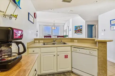 a kitchen with a sink and a microwave at 909-Seychelles in Panama City Beach