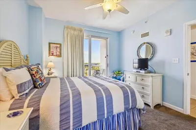 a bedroom with a bed and a tv and a window at 909-Seychelles in Panama City Beach