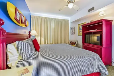 a bedroom with a large bed with a tv on it at 909-Seychelles in Panama City Beach