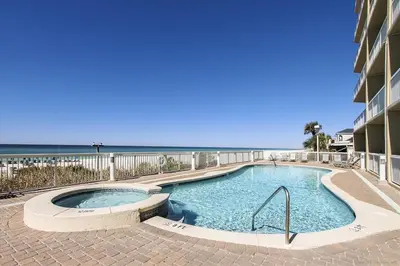 a swimming pool with the ocean in the background at 909-Seychelles in Panama City Beach