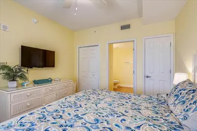 a bedroom with a bed and a flat screen tv at 804-Tidewater in Panama City Beach