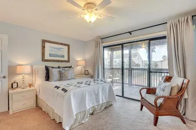a bedroom with a bed and a large window at Breezy PCB Retreat with Balcony - Walk to Beach! in Panama City Beach
