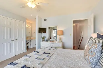 a bedroom with a bed and a television in it at Breezy PCB Retreat with Balcony - Walk to Beach! in Panama City Beach