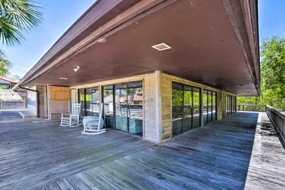 an outdoor deck with chairs on a house at Breezy PCB Retreat with Balcony - Walk to Beach! in Panama City Beach