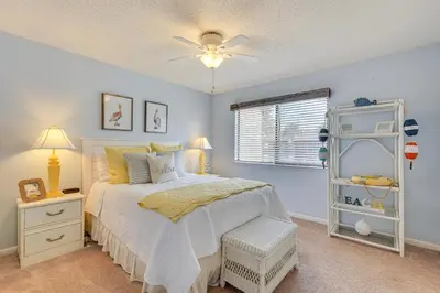 a bedroom with a bed and a ceiling fan at Breezy PCB Retreat with Balcony - Walk to Beach! in Panama City Beach