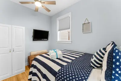 a bedroom with a bed and a ceiling fan at Beach Bay Getaway! Bayfront 4BR 4BA House Sleeps 12 Private pool Boat dock in Panama City Beach