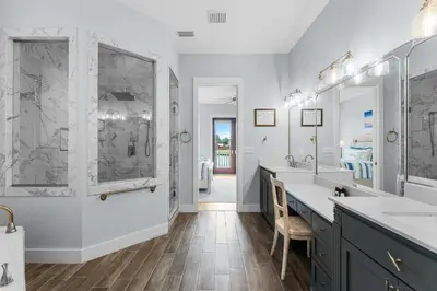 a bathroom with two sinks and two mirrors at Beach Bay Getaway! Bayfront 4BR 4BA House Sleeps 12 Private pool Boat dock in Panama City Beach
