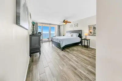 a bedroom with a bed and a large window at Dunes of Panama 2104E in Panama City Beach