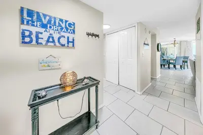 a hallway with a table and a sign on the wall at Dunes of Panama 2104E in Panama City Beach