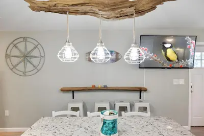 a dining room with a table and a picture of a bird on the wall at Sea Breeze House- 3 bd 2 ba 5 min walk to beach in Panama City Beach