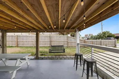 a pavilion with chairs and a bench and a fence at Sea Breeze House- 3 bd 2 ba 5 min walk to beach in Panama City Beach