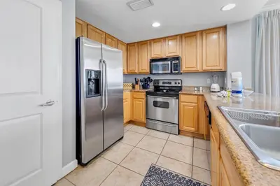 a kitchen with wooden cabinets and stainless steel appliances at Grandview East 1201 in Panama City Beach