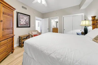 a bedroom with a large white bed and a dresser at Grandview East 1201 in Panama City Beach
