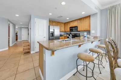 a kitchen with a counter and bar stools at Grandview East 1201 in Panama City Beach