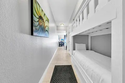 a bedroom with white beds and a painting on the wall at Tidewater 2604 - SunBeam Dreams in Panama City Beach