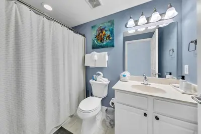 a bathroom with a toilet and a sink at Tidewater 2604 - SunBeam Dreams in Panama City Beach