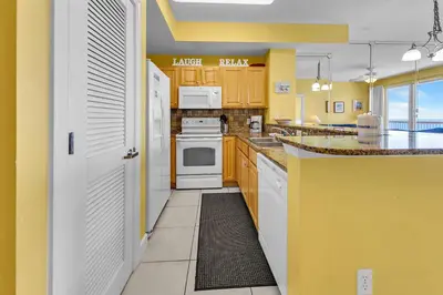 a kitchen with yellow walls and white appliances at Sunrise Beach #2107 in Panama City Beach