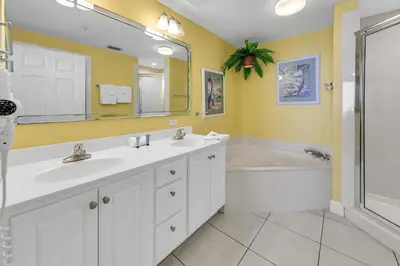 a bathroom with two sinks and a tub and a mirror at Sunrise Beach #2107 in Panama City Beach