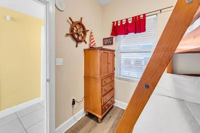 a bedroom with a bed and a dresser and a window at Sunrise Beach #2107 in Panama City Beach