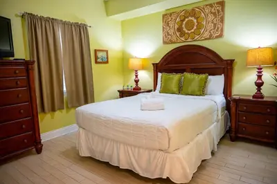 a bedroom with a bed and a dresser and a television at Treasure Island 1910 in Panama City Beach