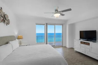 a bedroom with a bed and a flat screen tv at Treasure Island 1612 in Panama City Beach