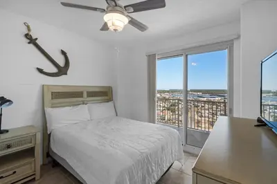 a bedroom with a bed and a desk and a window at Treasure Island 1612 in Panama City Beach