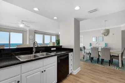 a kitchen with a sink and a dining room at Treasure Island 0801 in Panama City Beach