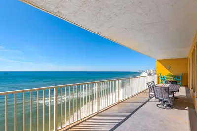 a balcony with two chairs and a view of the ocean at Treasure Island 0801 in Panama City Beach