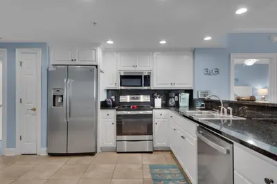 a kitchen with white cabinets and stainless steel appliances at Treasure Island 1706 in Panama City Beach