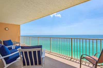 a balcony with chairs and a view of the ocean at Treasure Island 1706 in Panama City Beach
