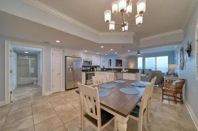 a dining room and kitchen with a table and chairs at Treasure Island 1706 in Panama City Beach