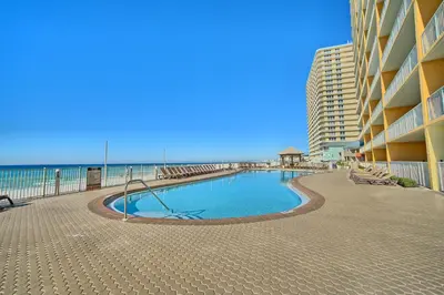 a swimming pool in front of a building next to the beach at Treasure Island 1806 in Panama City Beach