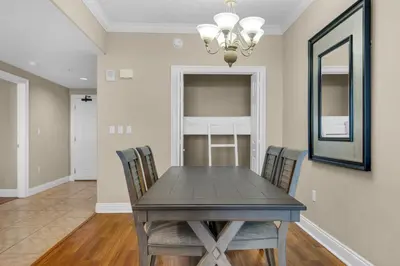 a dining room with a table and chairs and a mirror at Treasure Island 1911 in Panama City Beach