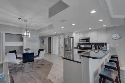 a kitchen and living room with a table and chairs at Treasure Island 0802 in Panama City Beach
