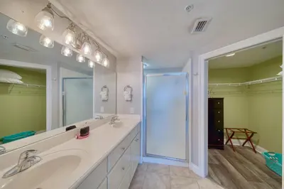 a bathroom with two sinks and a large mirror at Treasure Island 1510 in Panama City Beach