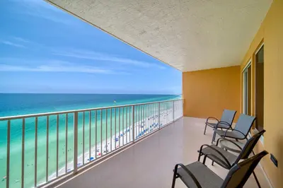 a balcony with chairs and a view of the ocean at Treasure Island 1510 in Panama City Beach