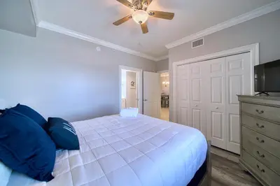 a bedroom with a bed and a ceiling fan at Treasure Island 1510 in Panama City Beach