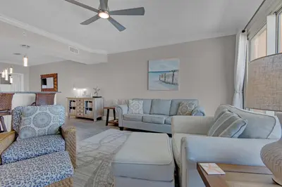 a living room with couches and a ceiling fan at Treasure Island 1811 in Panama City Beach