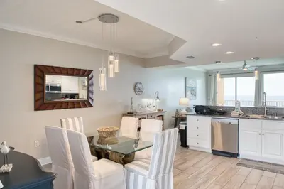 a kitchen and dining room with a table and chairs at Treasure Island 1811 in Panama City Beach
