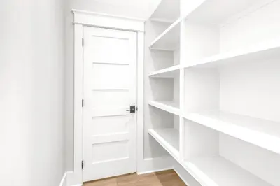a white closet with white shelves and a door at New-Walk To Beach - Private Heated Pool in Inlet Beach