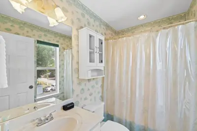 a bathroom with a sink and a toilet and a window at Spacious 3-Story Bayfront Home Perfect for Family Fun & Relaxation in Panama City