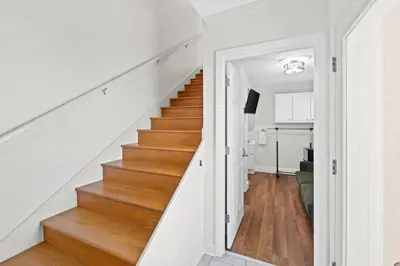 a staircase in a home with white walls and wood floors at Spacious 3-Story Bayfront Home Perfect for Family Fun & Relaxation in Panama City