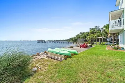 a row of boats sitting on the shore of a lake at Spacious 3-Story Bayfront Home Perfect for Family Fun & Relaxation in Panama City